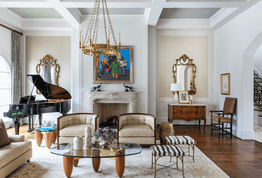 Không gian phòng khách mang phong cách Địa Trung Hải sử dụng sofa màu be, bàn trà gỗ tròn và đèn treo sắt rèn thủ công
