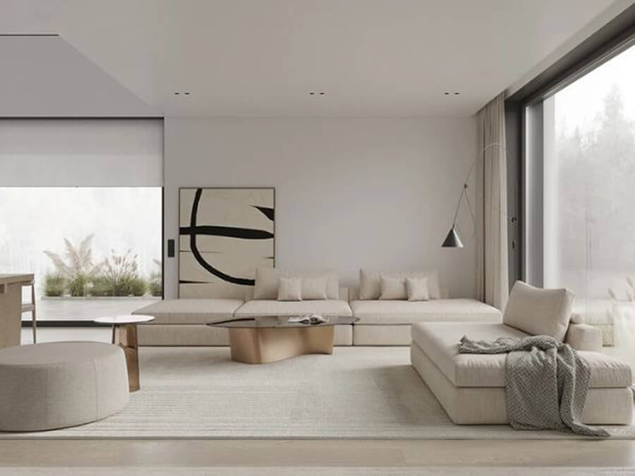 Phòng khách biệt thự tối giản với sofa dáng thấp, bàn trà đơn sắc và cửa kính lớn lấy sáng tự nhiên